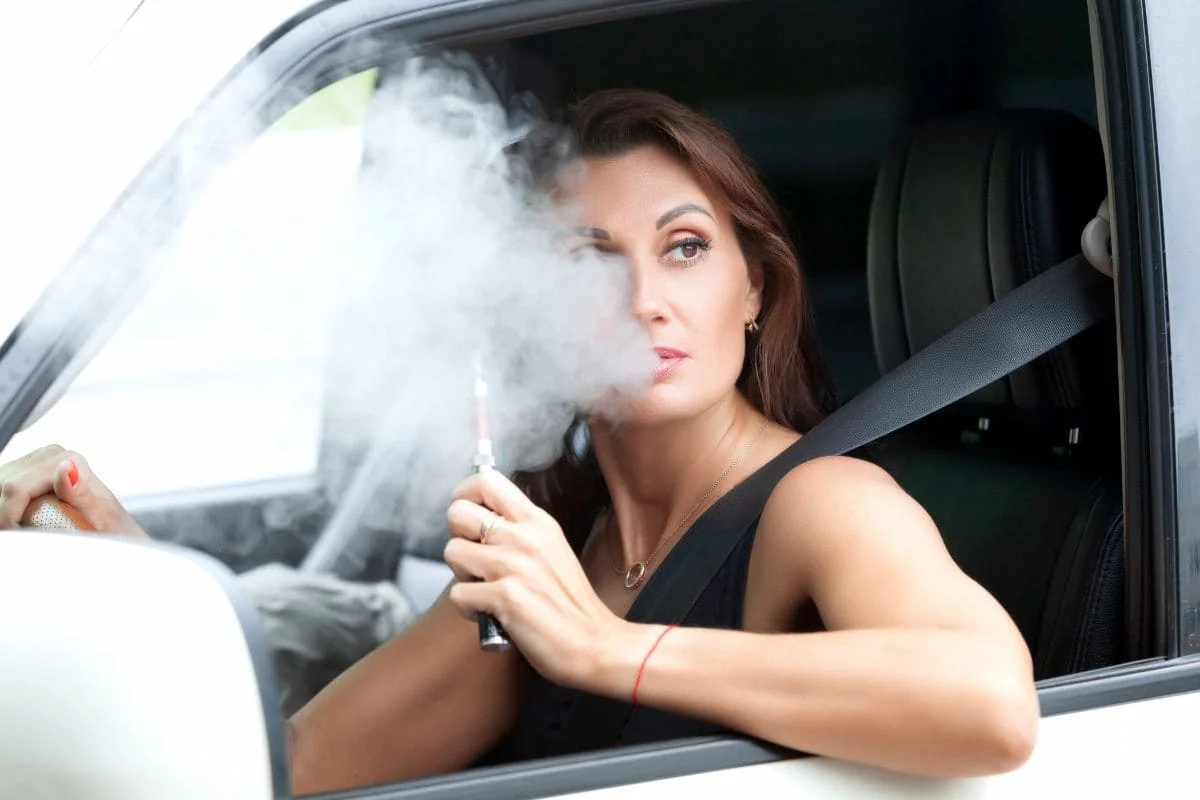 nie wapować podczas ładowania e-papierosa, vaping passthrough ryzyko, osoba używająca vape podłączonego do ładowarki - Błędy w wapowaniu, których należy unikać - E-papierosy SMOKO ...
