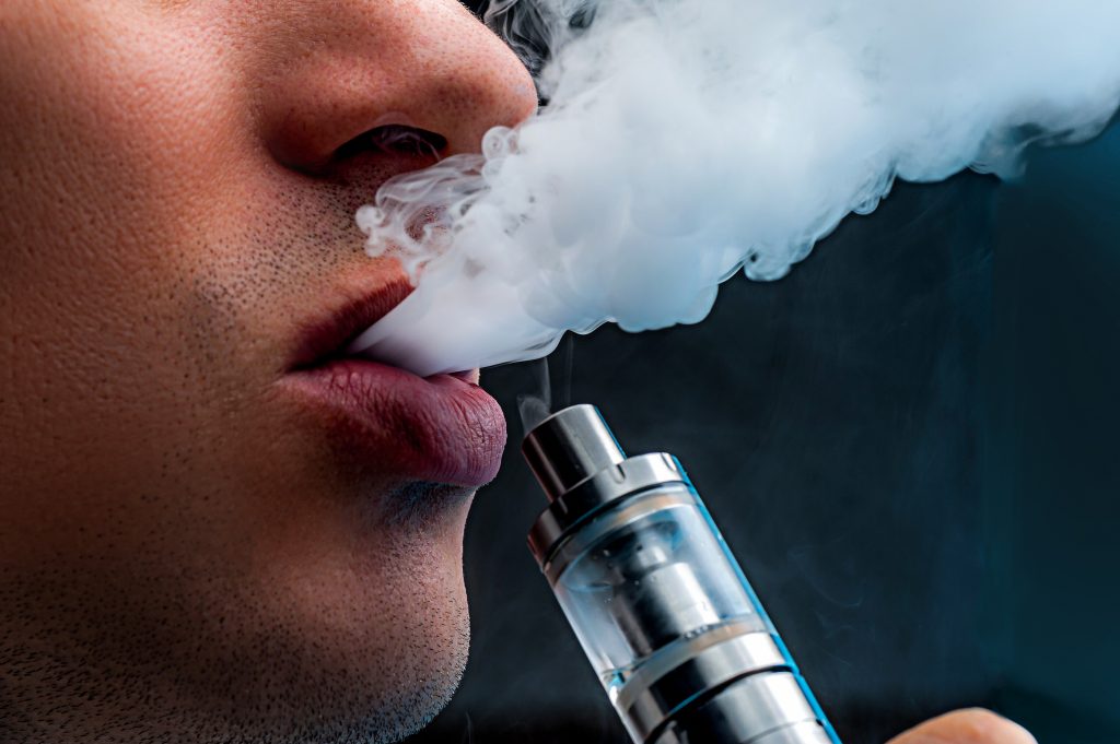 osoba zaciągająca się e-papierosem duża chmura, intensywny throat hit vape, potężny wygar e-papieros - Throat hit, czyli skąd się bierze drapanie w gardle ...