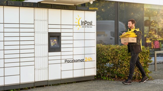 Zdjęcie lub ilustracja Paczkomatu InPost z osobą odbierającą paczkę, podkreślające wygodę i dostępność 24/7.